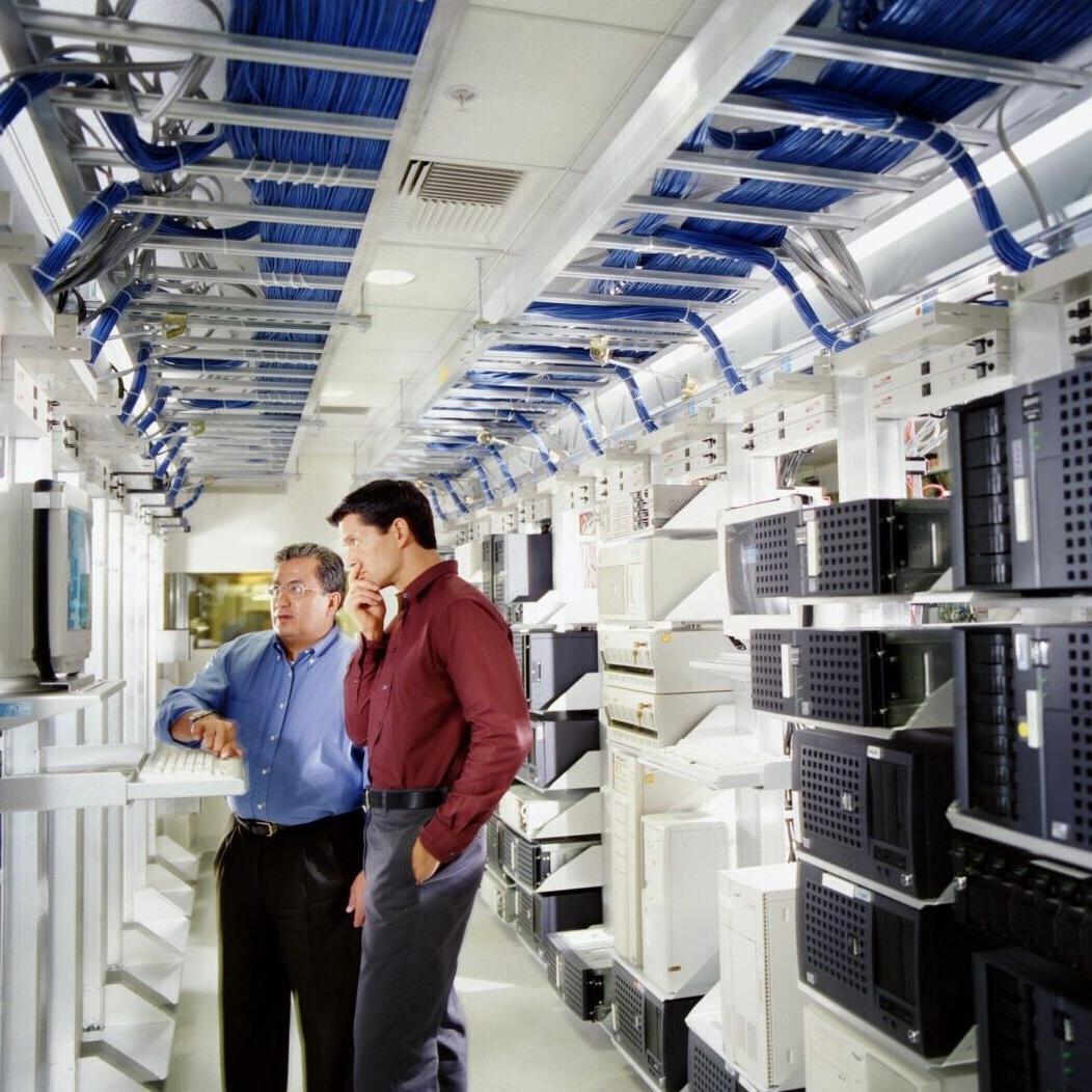 Two Men Looking at Drives & Working Inside of Data Center